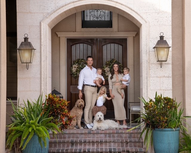 A family standing in front of a doorDescription automatically generated