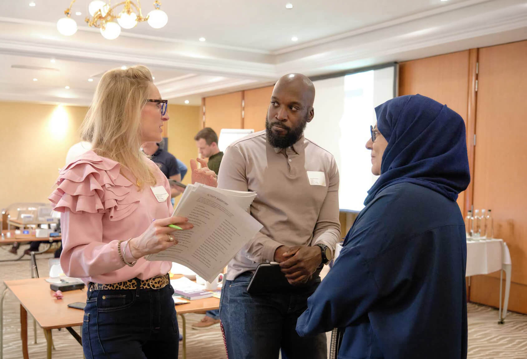 Three Strategic Coach participants talking in workshop for entrepreneurs