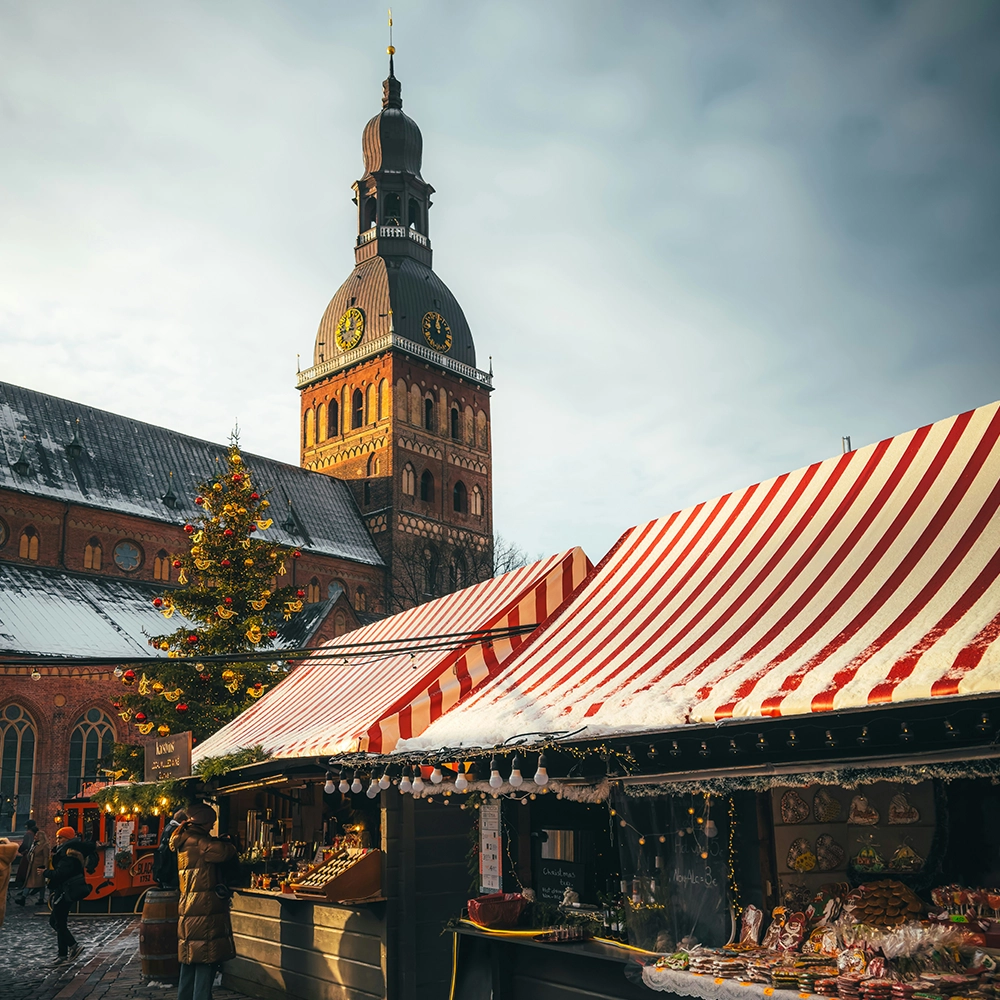 European Christmas market in front of a large building with a clock tower