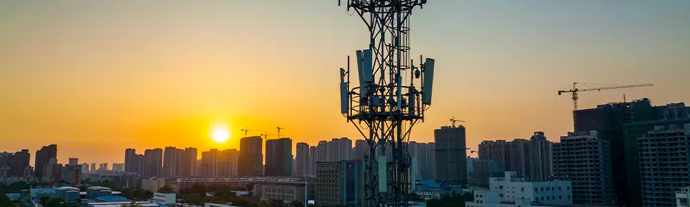cell tower in a city at sunset