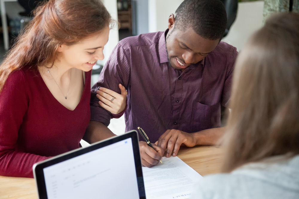 couple signing agreement at bank