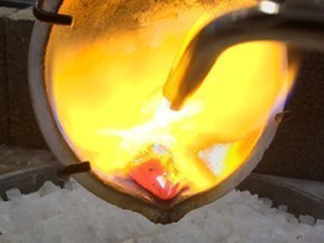 torch heating molten metal in a crucible for jewelry casting