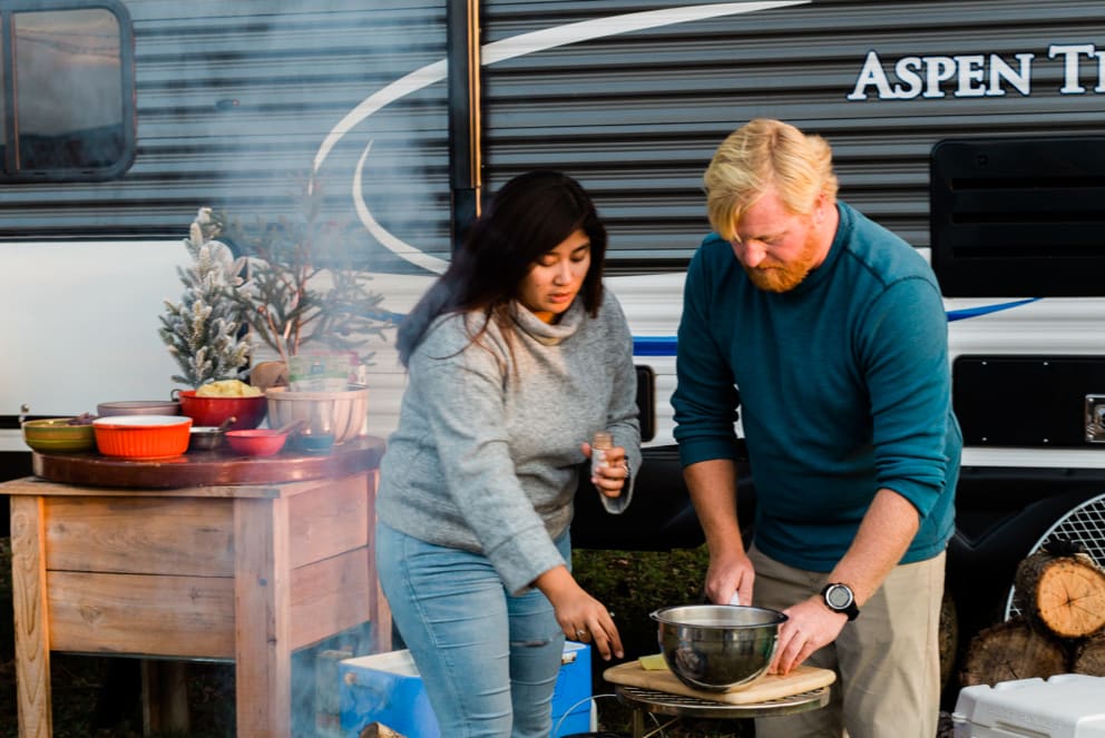 couple cooking outside RV for Christmas