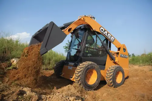 CASE skid steer with a bucket attachment dumping dirt onto a pile