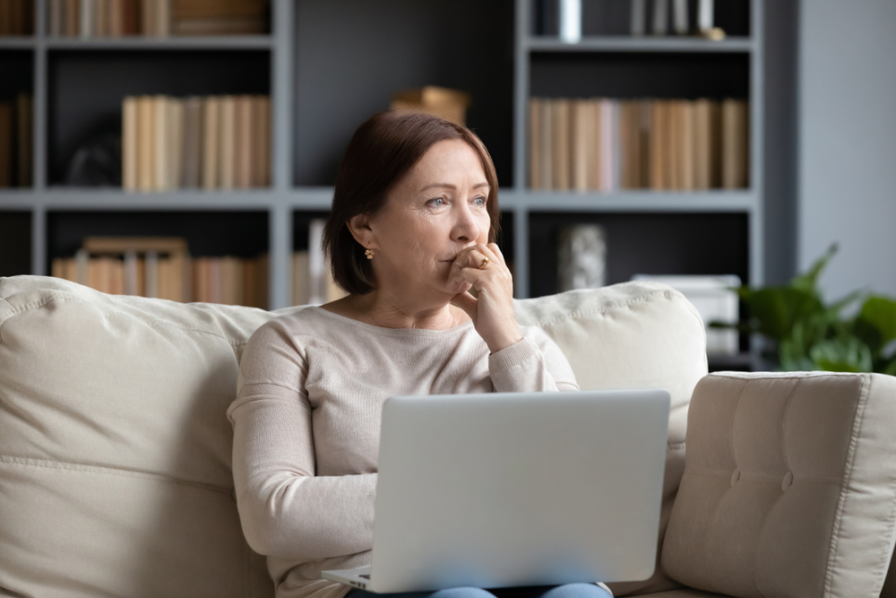 Woman using a laptop with a concerned expression