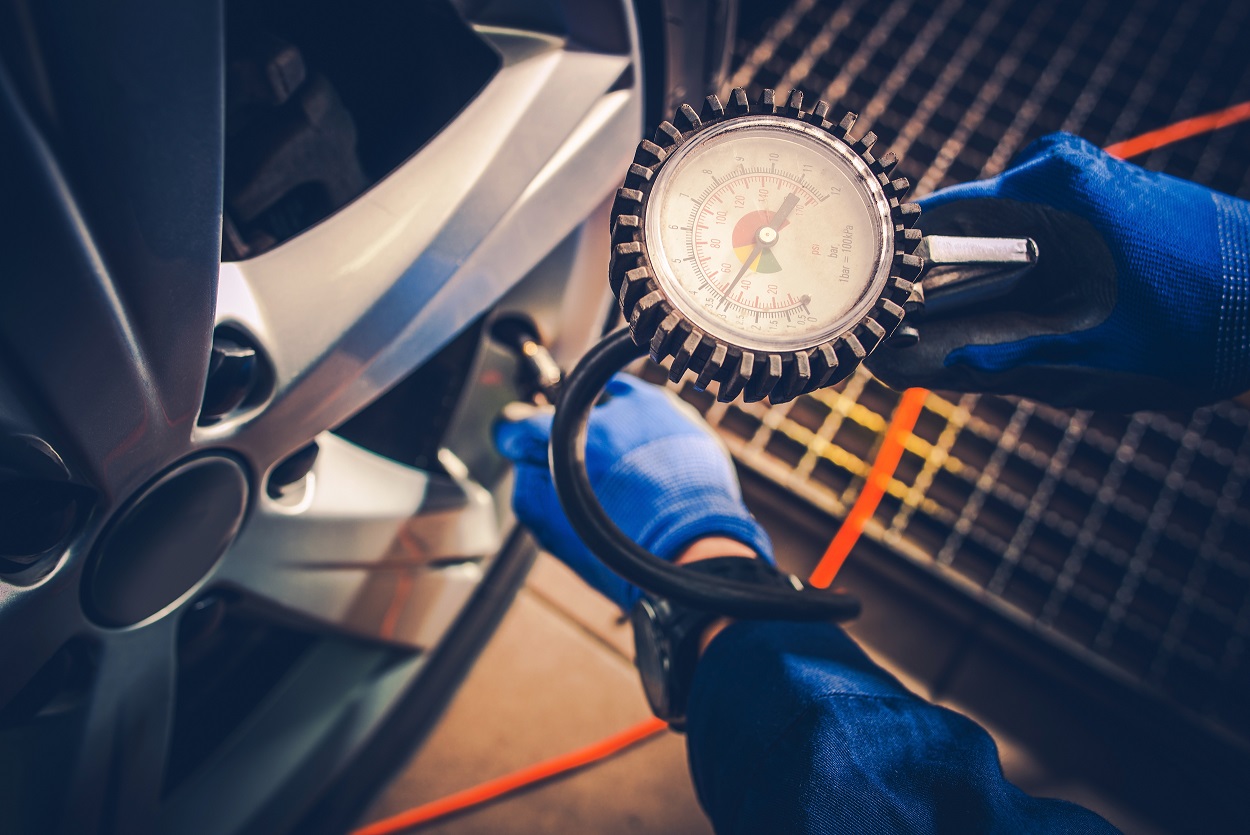 someone checking their tyre pressure with a pressure gauge 