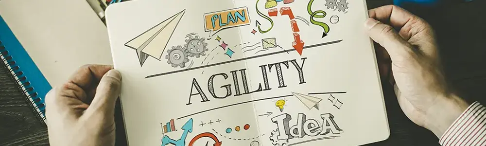 hands holding paper with the word agility on it