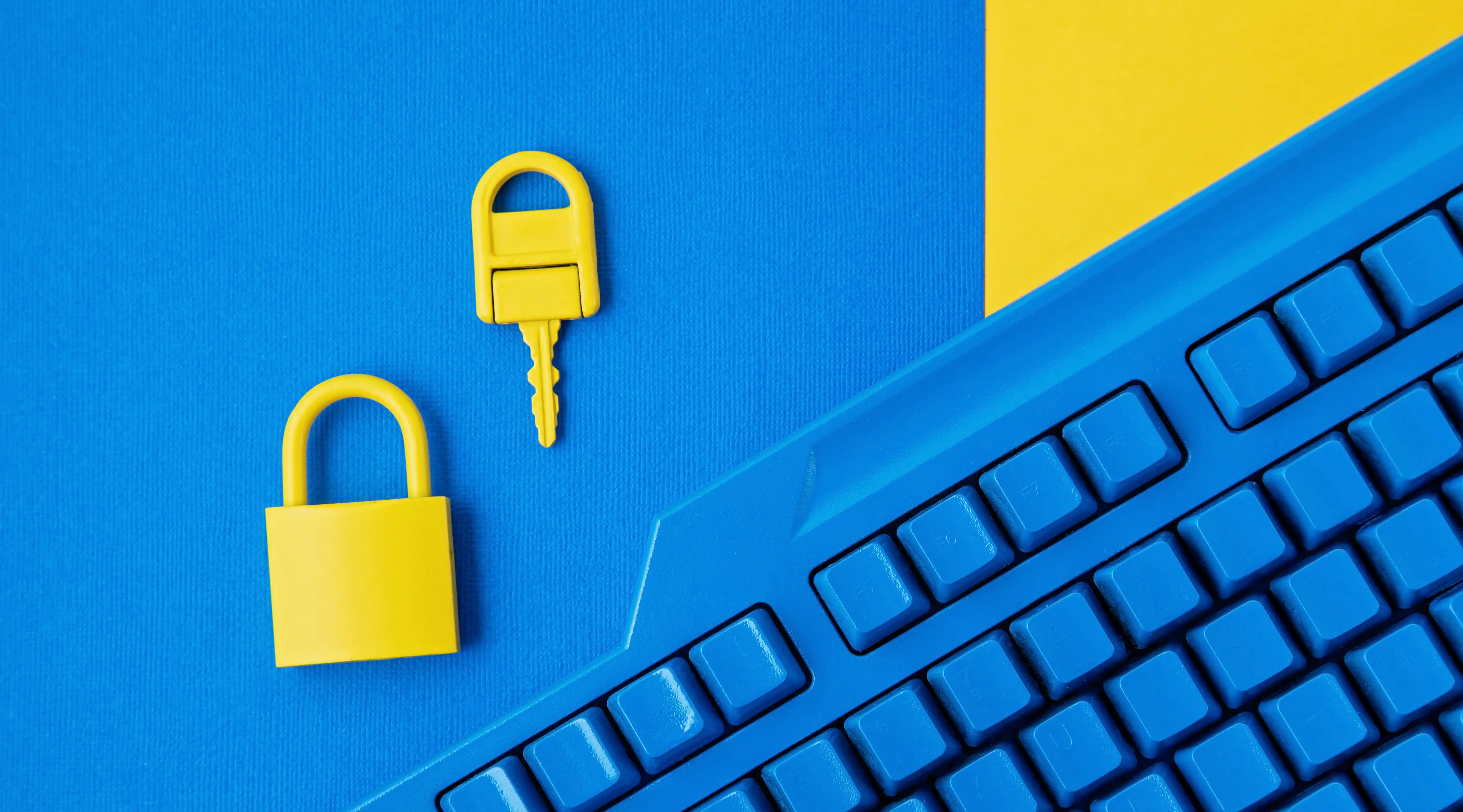 Yellow padlock and key with keyboard representing data security and IP protection through fair pay loyalty