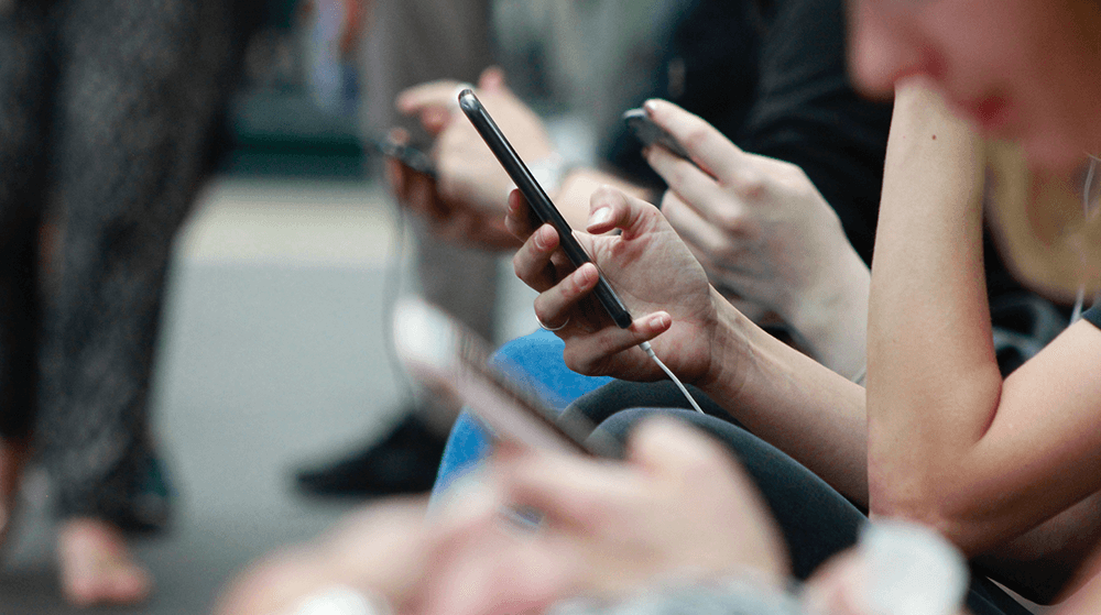 Women scrolling through phones while riding subway