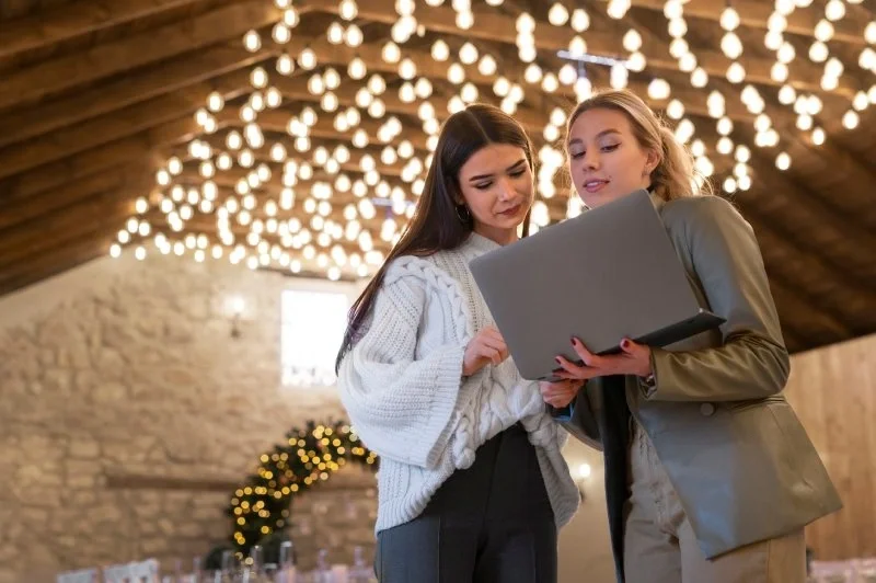 Two event organizers reviewing ticketing platform options together on a laptop