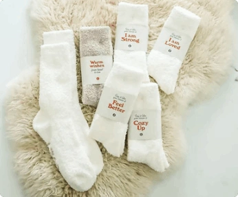 6 pairs of socks lay atop a fuzzy rug