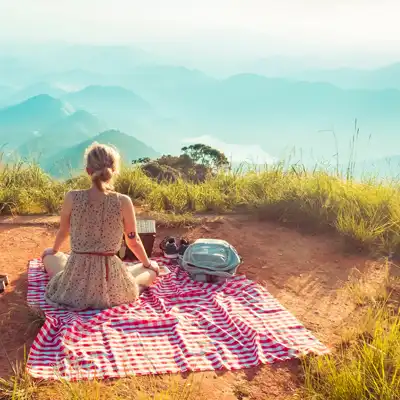 Woman has a cliffside picnic.