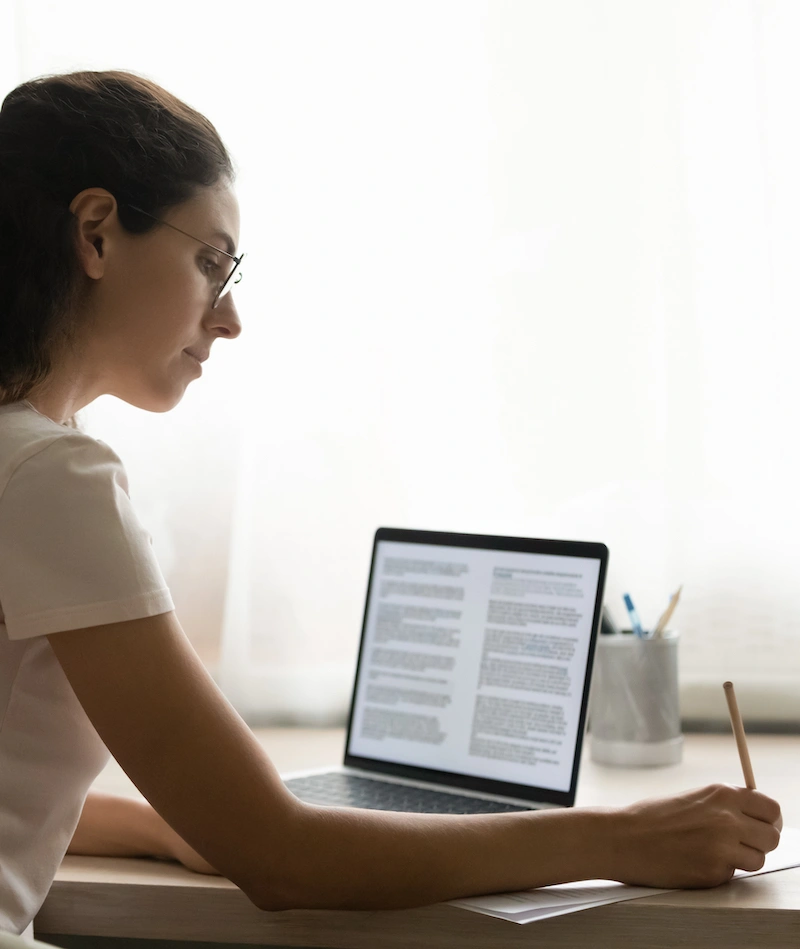 A woman sitting in front of a computer screen with two columns of text.