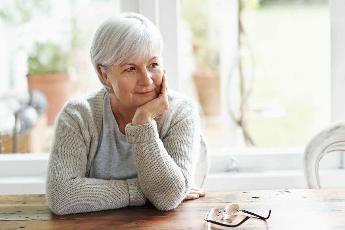 Woman sitting at a table, wondering what the Medicare General Enrollment Period is
