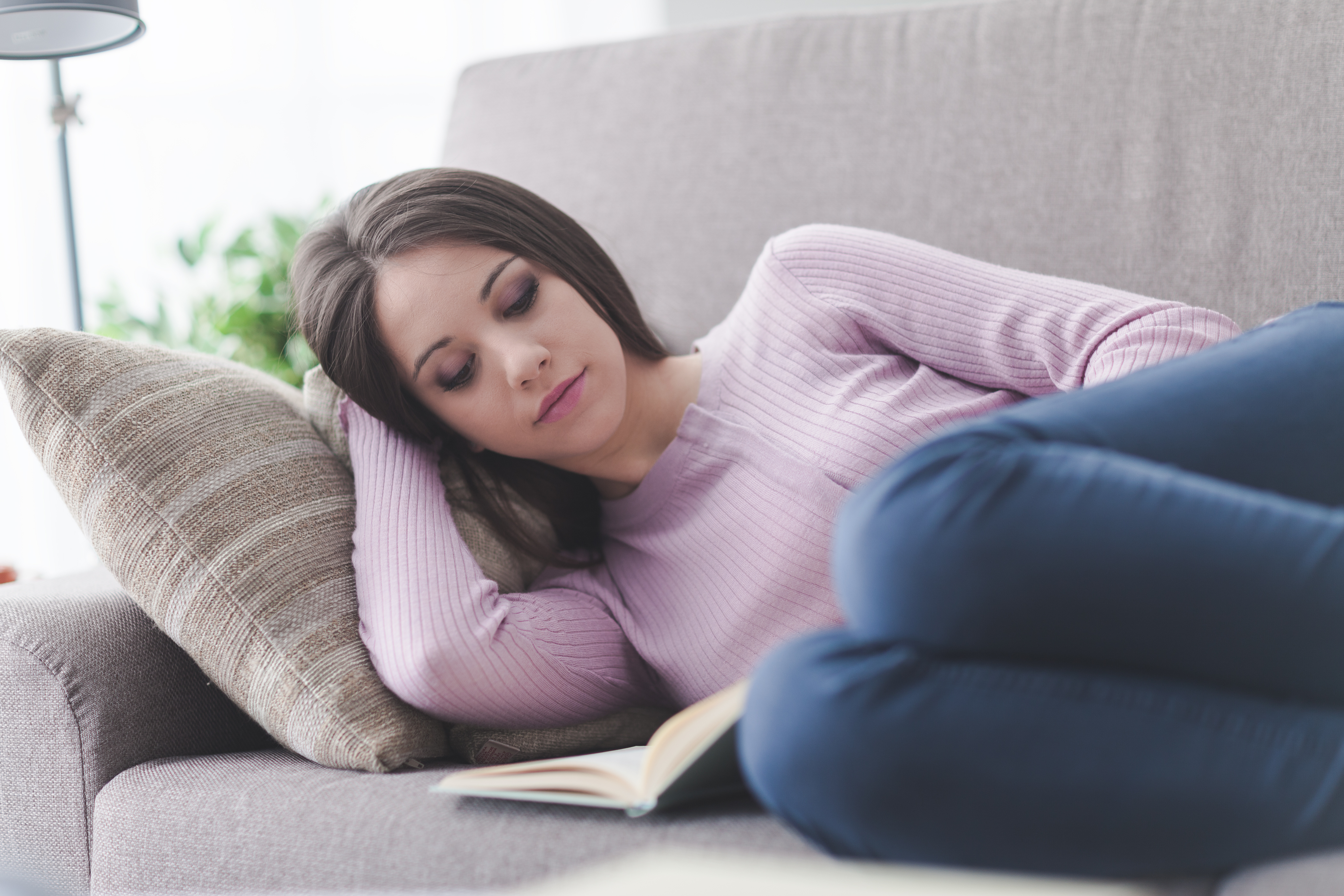 Girl reading a book on the sofa
