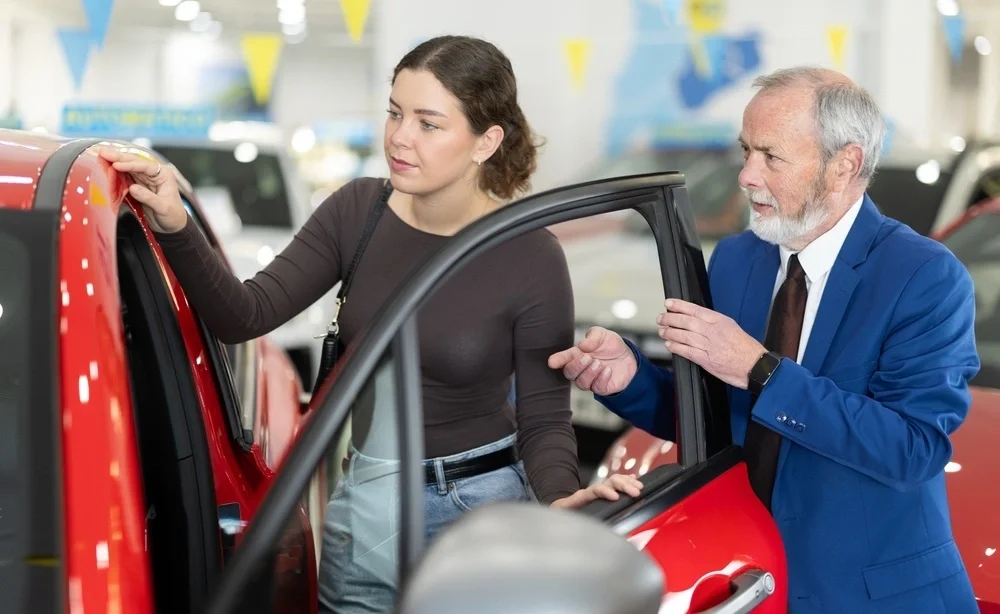 Woman viewing a new car in showroom