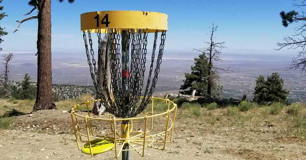 A disc golf basket with an expansive view behind it