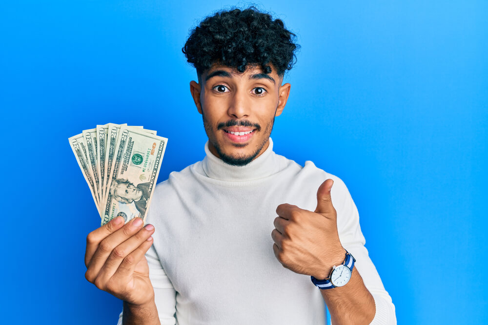 man giving thumbs up with payday loans cash