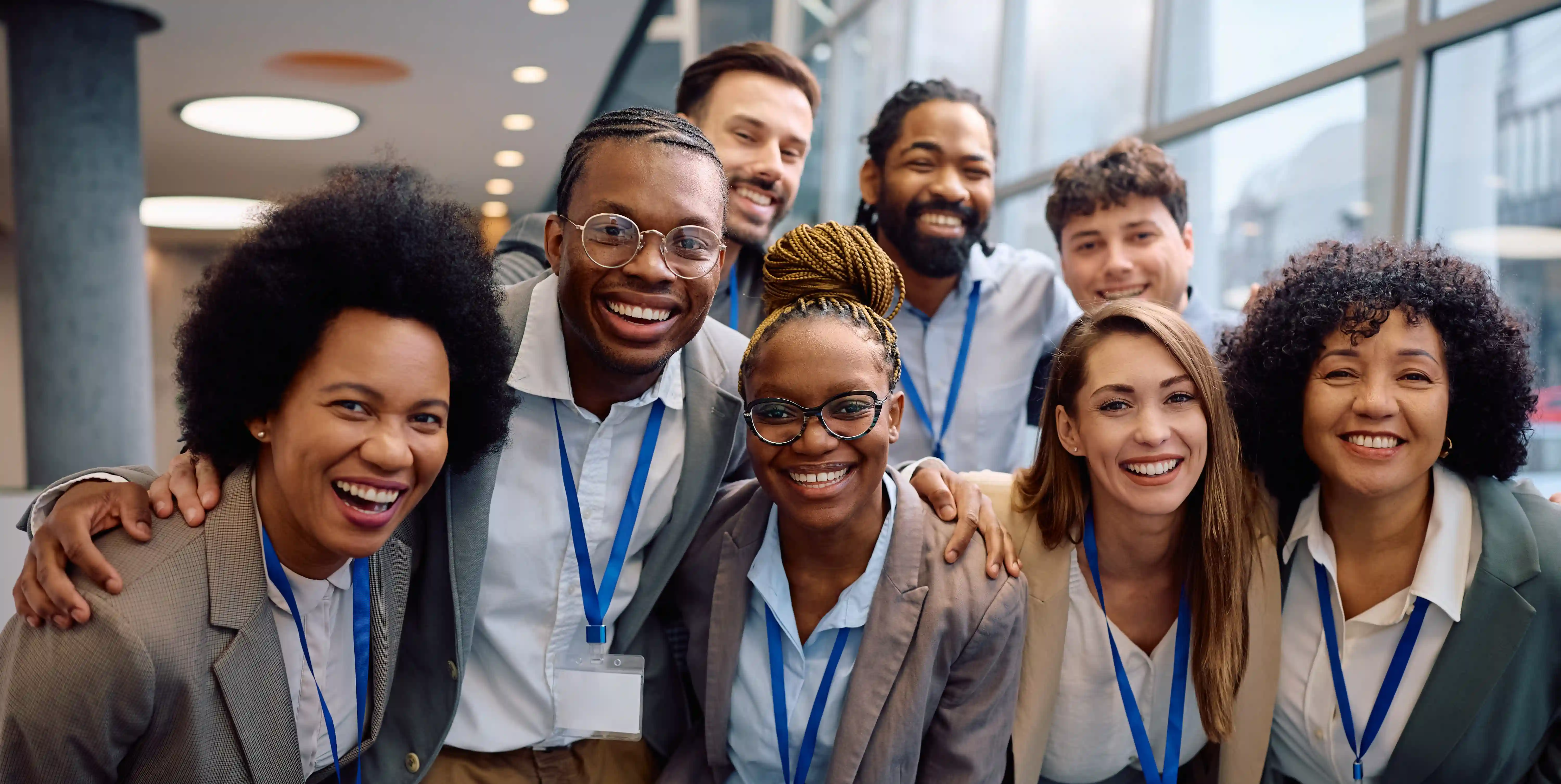 Happy multiracial business team at conference representing inclusive workplace culture and impact-led hiring