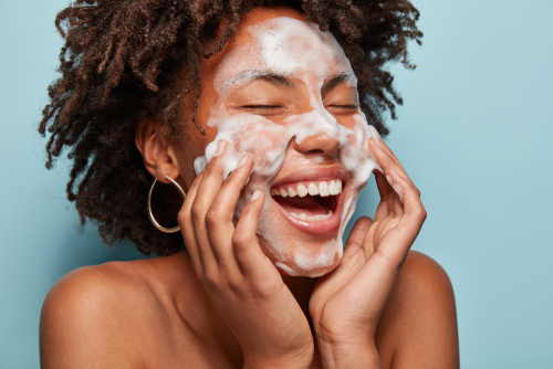 A woman washing her face with a smile