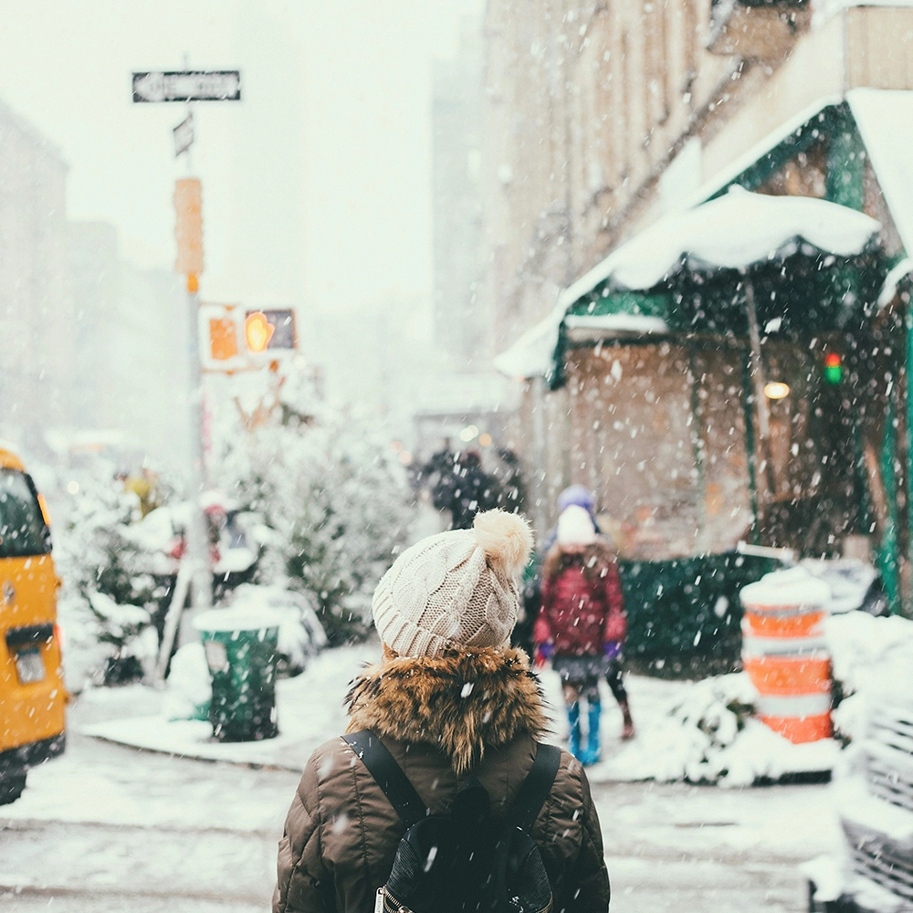 A traveler in a city during winter weather.