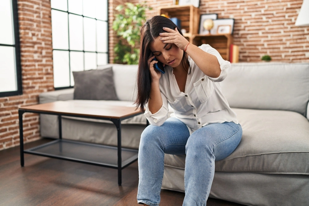 Worried woman on the phone at home