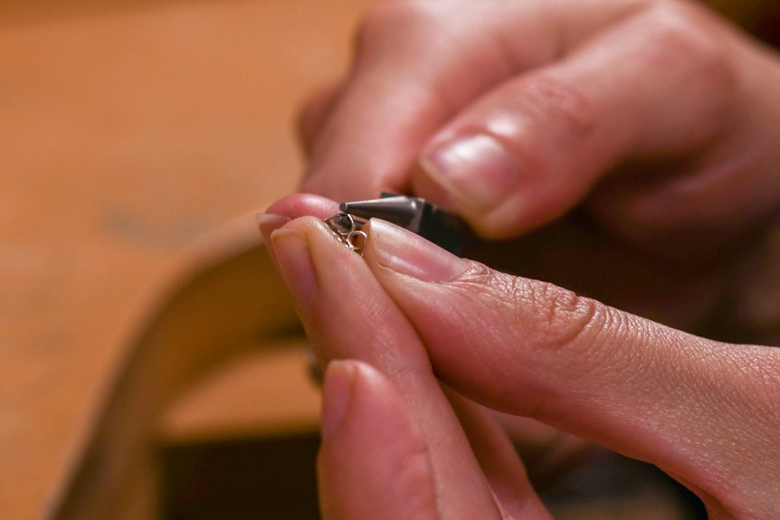 Tightening earring back ears with round nose pliers