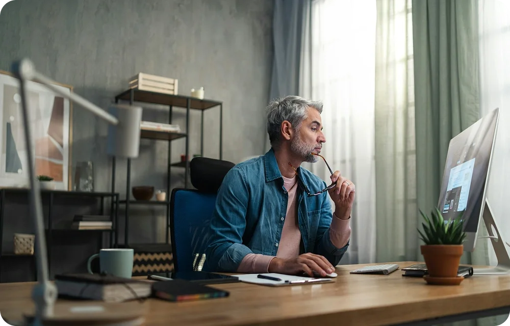 Man working on a computer talking to someone on the screen