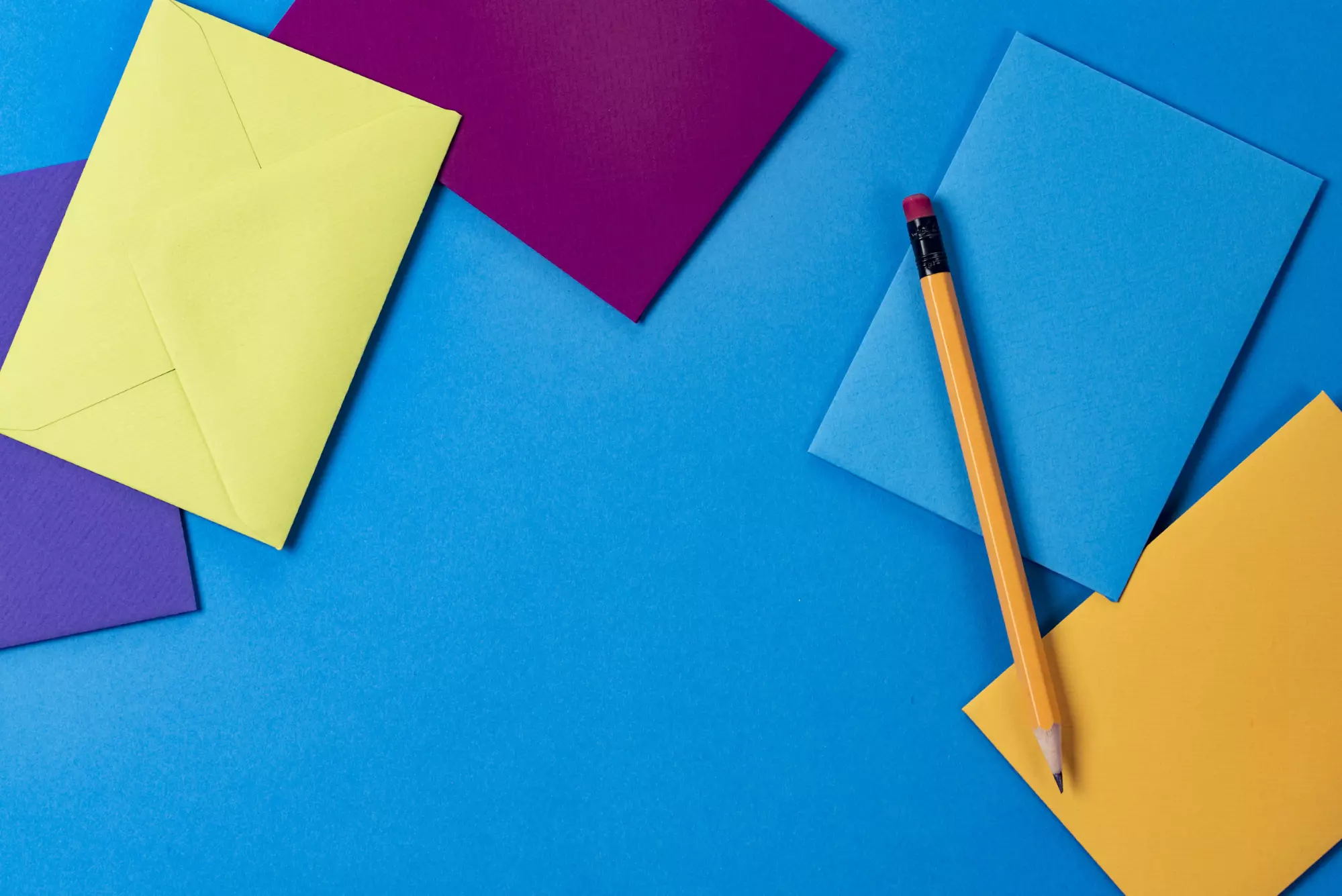 A stock image of colorful envelopes and pencils 