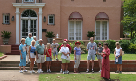 Group of people standing on the front lawn of a historical landmark