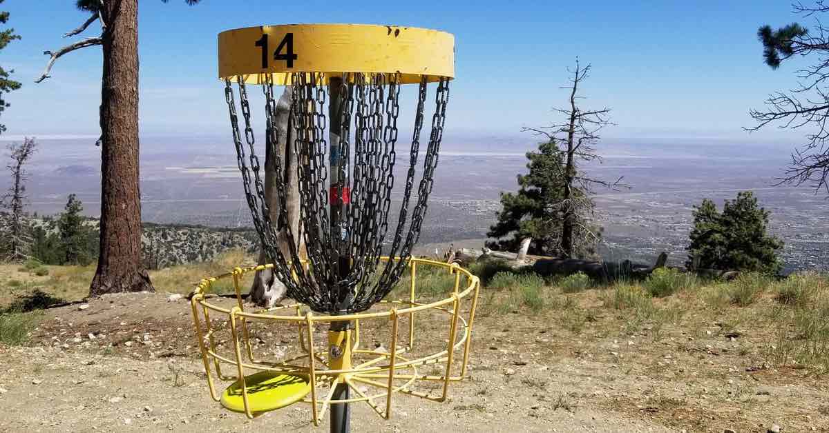 A disc golf basket with an expansive view behind it