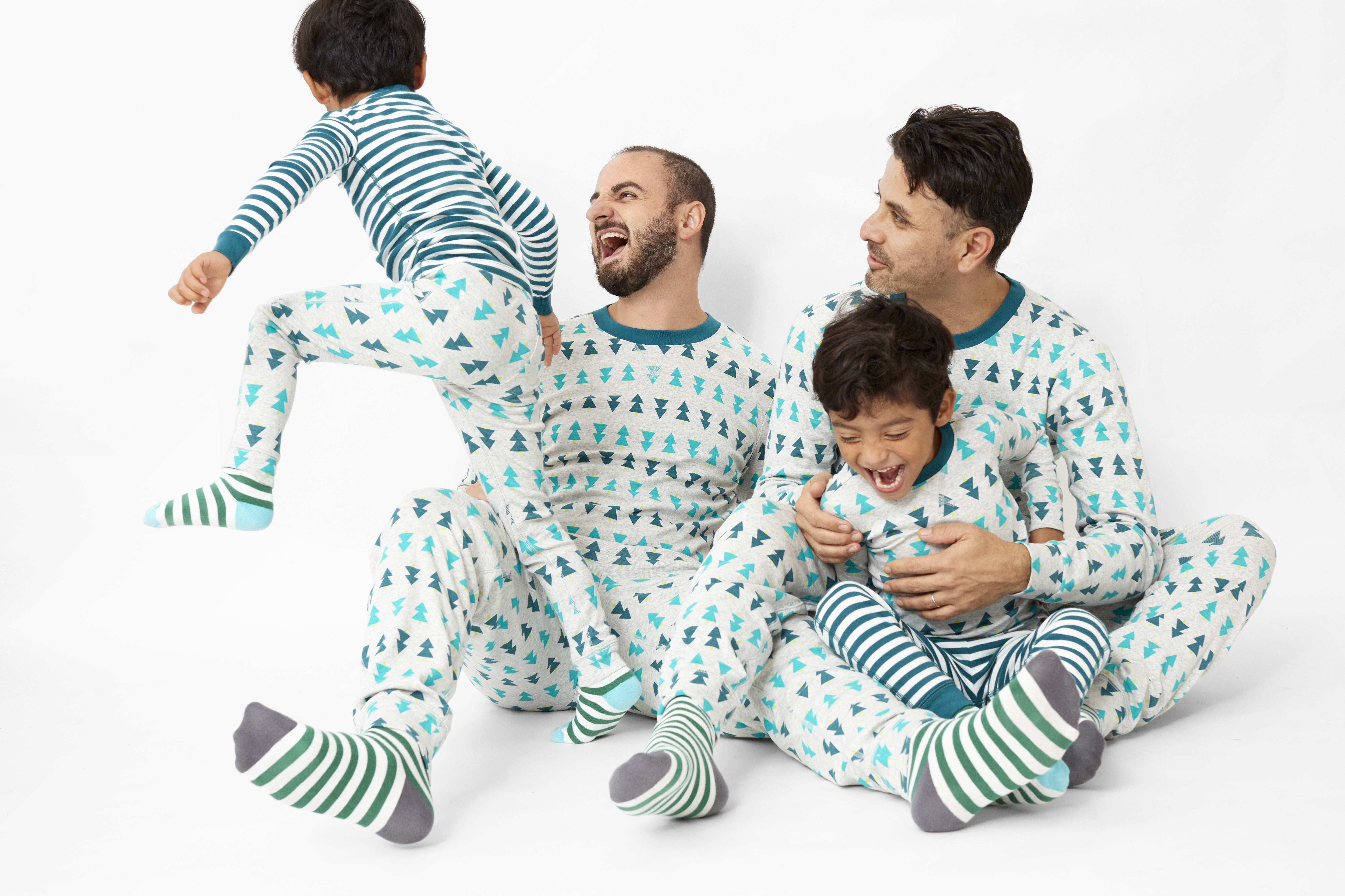 two dads and twin boys wearing tree pajamas