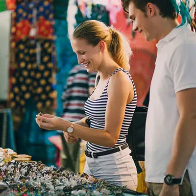 Couple looking at jewelry in market.