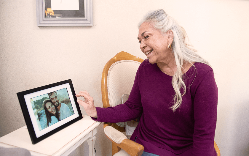 Mom smiling and looking at image on digital photo frame