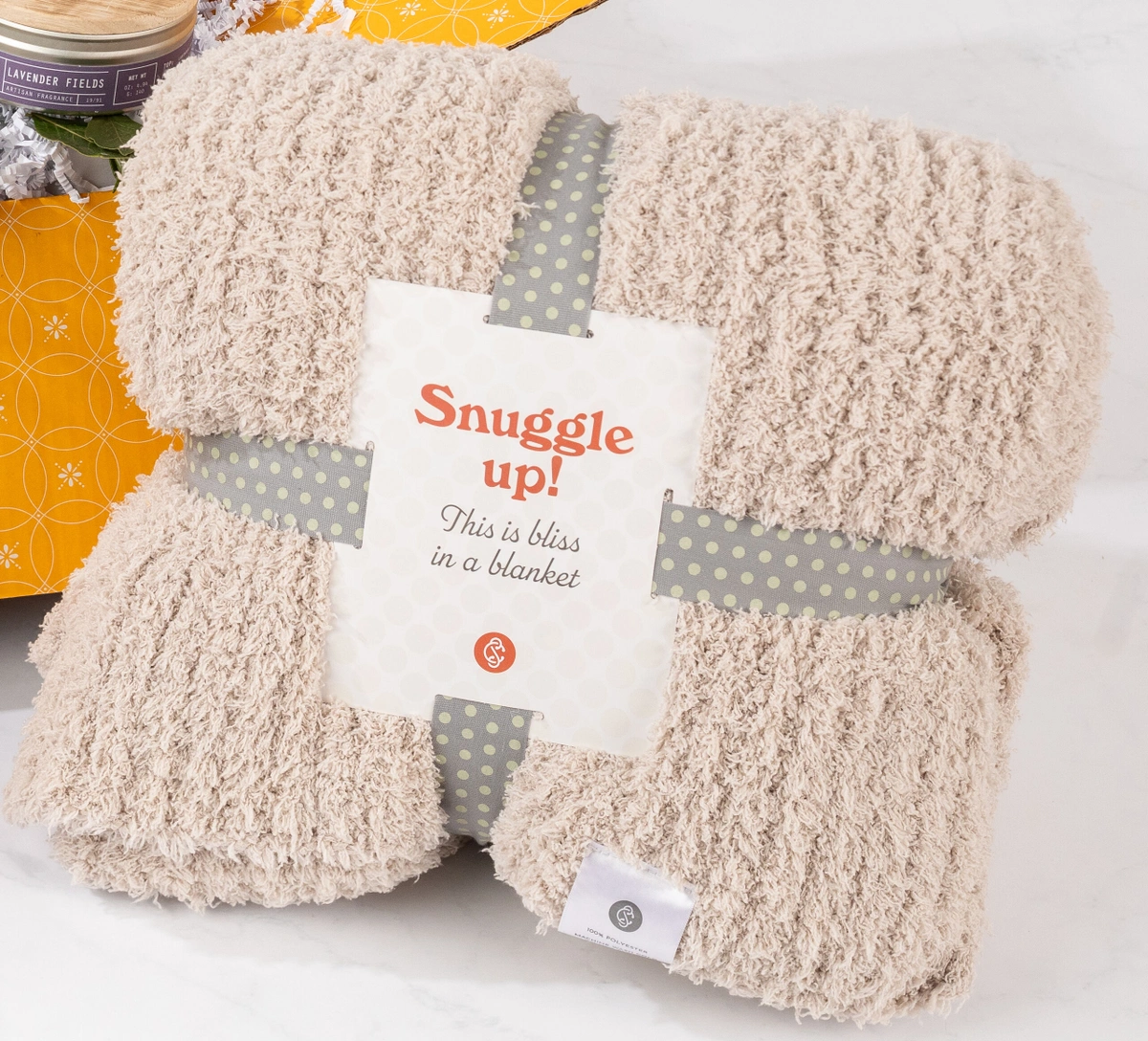 A cozy comfort throw is bundled with a label that says "Snuggle up!"