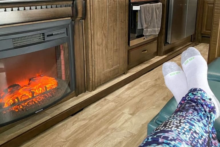 feet next to RV fireplace
