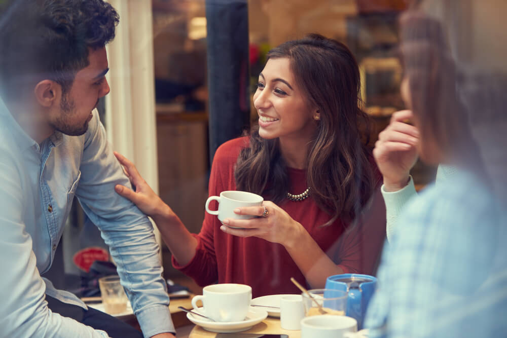 A woman enjoying a hot drink with friends.