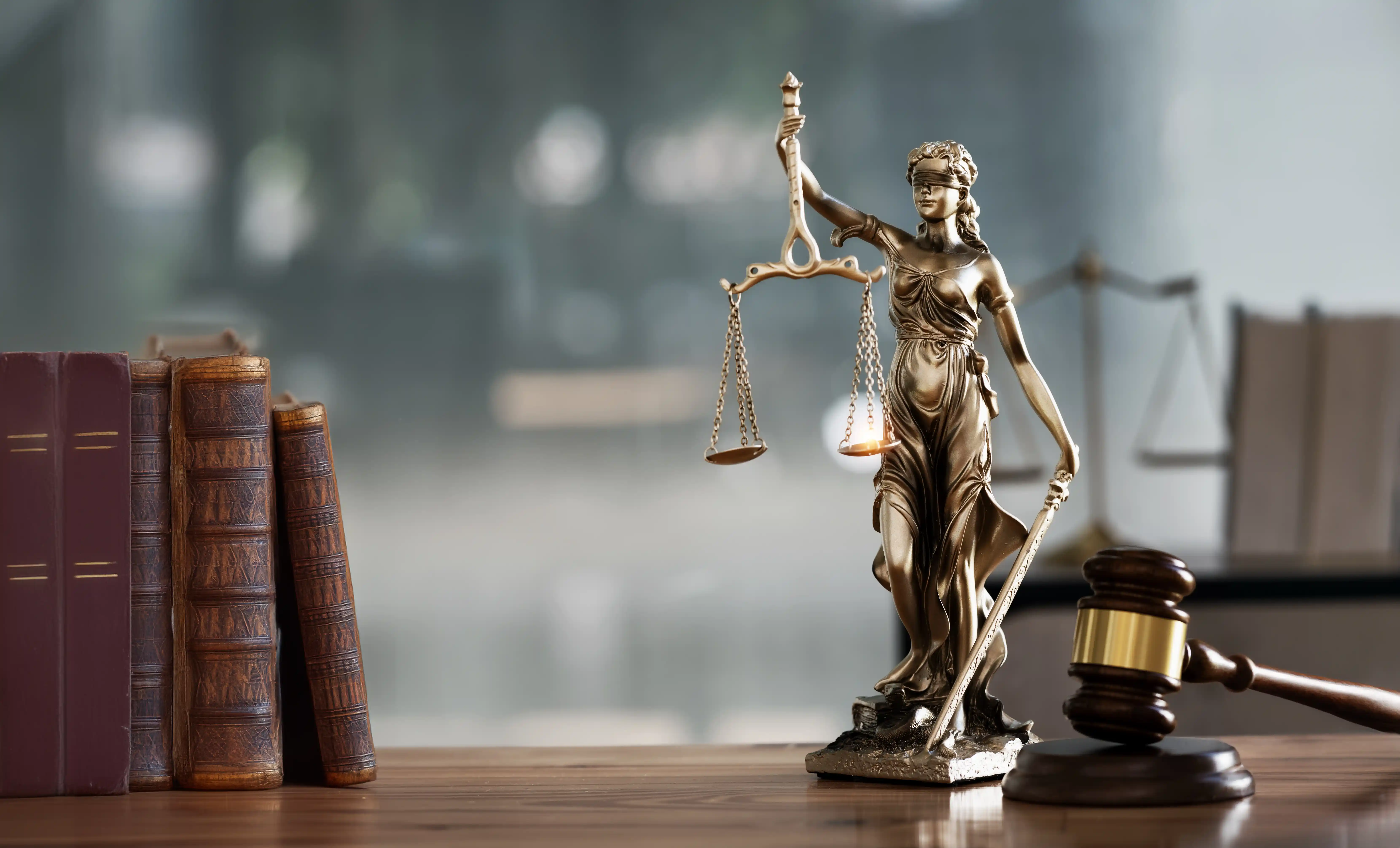 Lady Justice statue with gavel and law books representing B Corp legal compliance