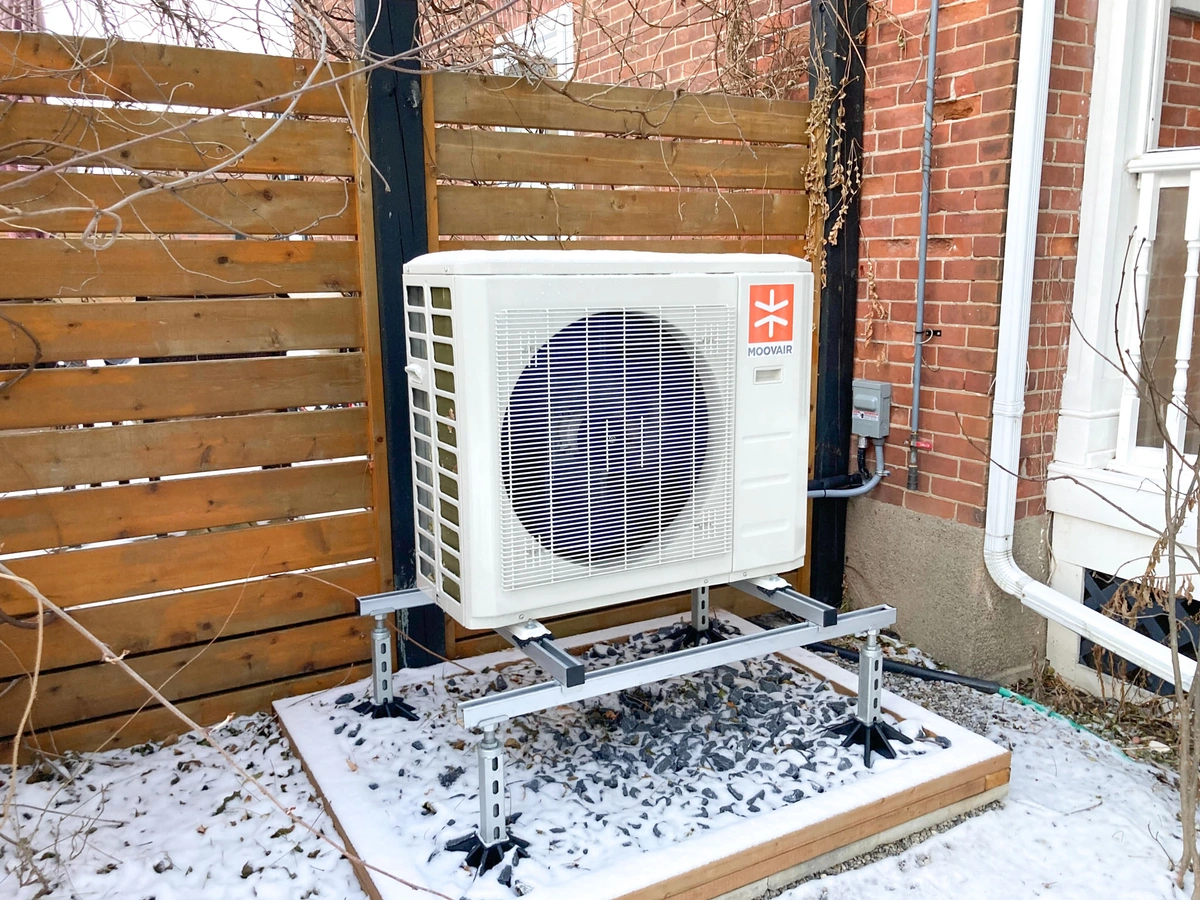A Moovair heat pump installed on the side of a home.