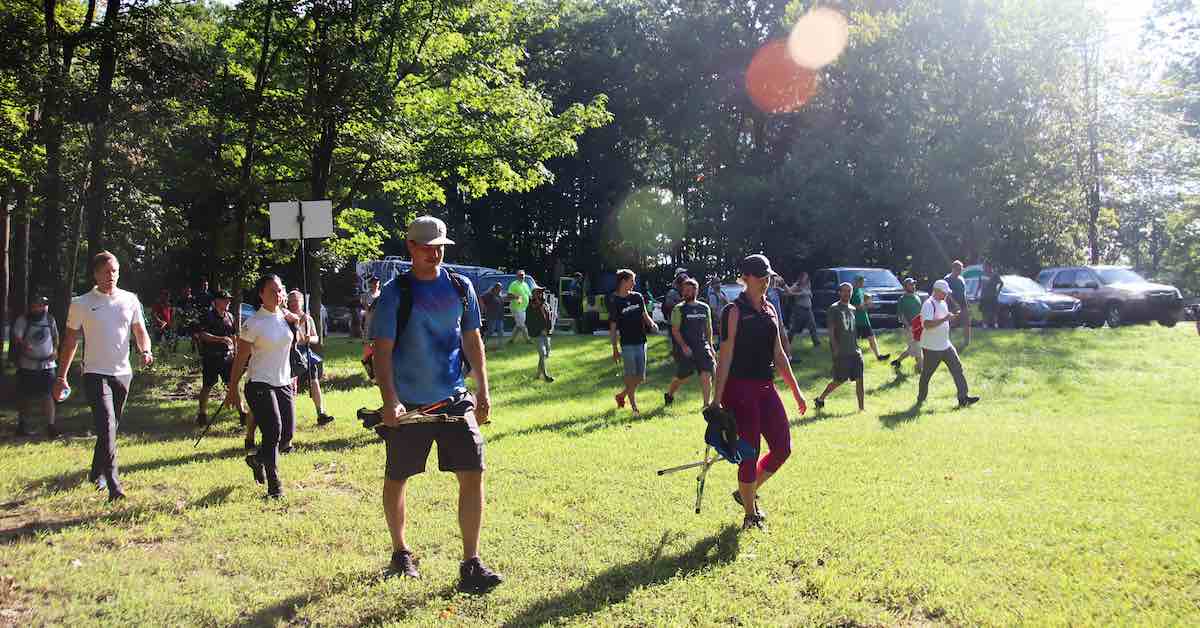 A group of people walking on a disc golf course