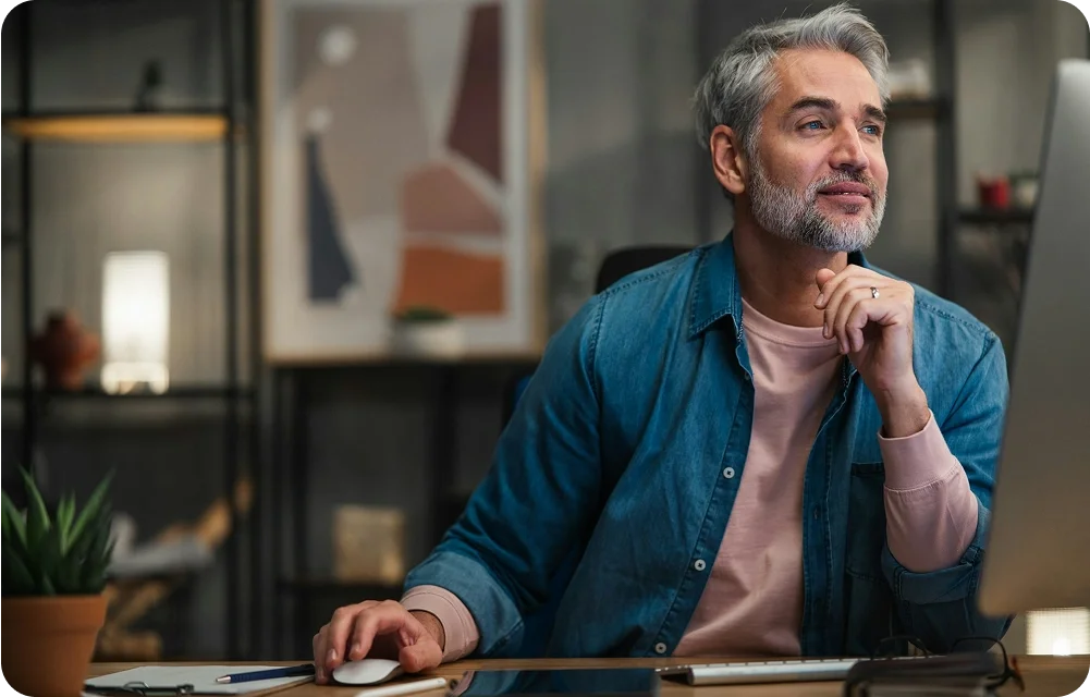 Man looking at the computer, using a mouse