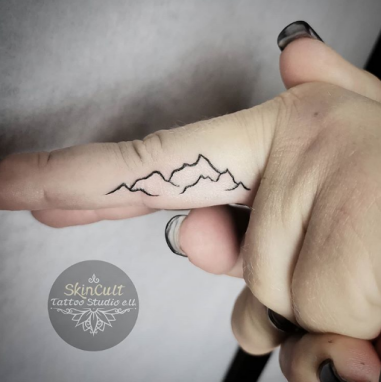 Minimalist mountain tattoo on lower back