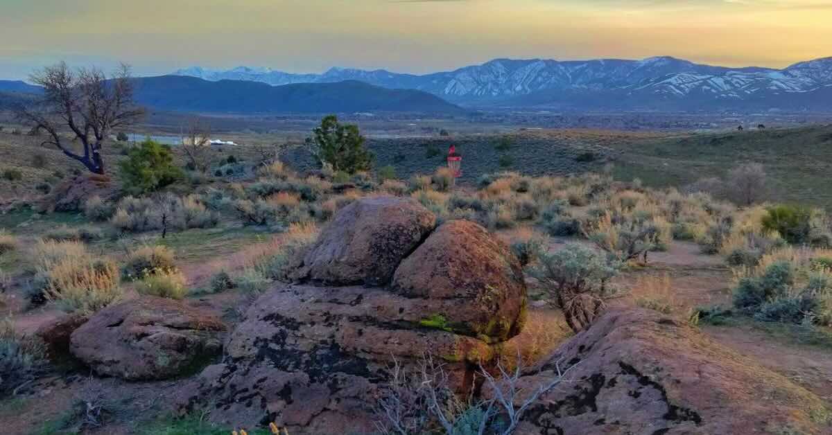 View of snow-capped mountains in the distance from an elevated area over western U.S. desert landscape