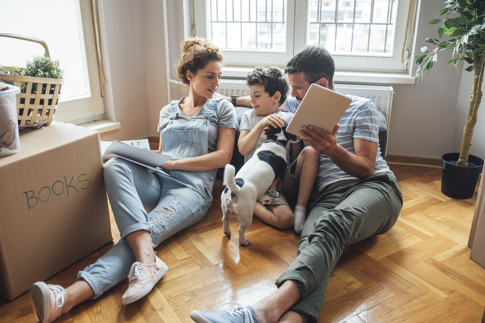 Happy family in new home sitting together on the floor
