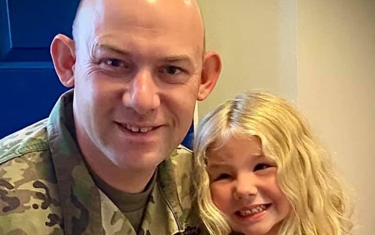 A man and little girl smiling widely for a photo
