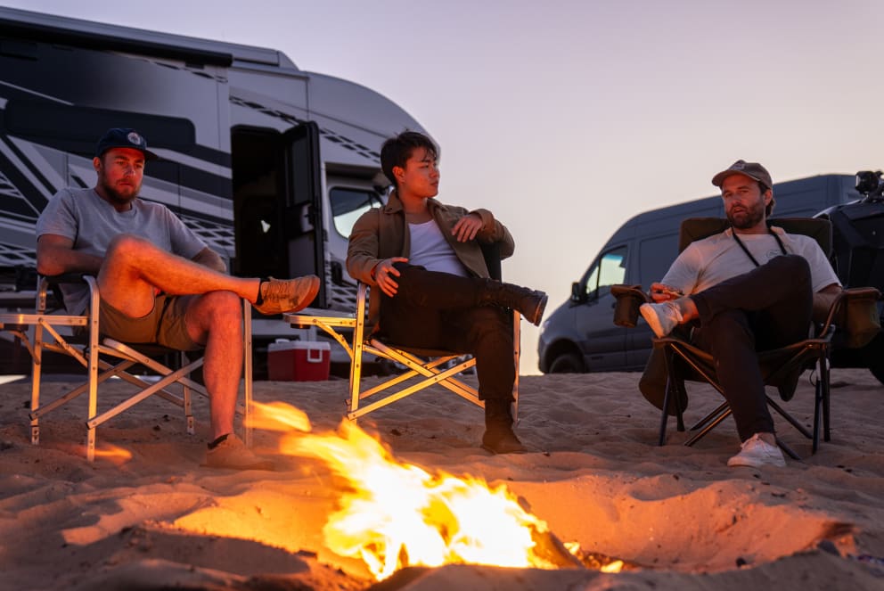 men at campfire in sand dunes with entegra accolade