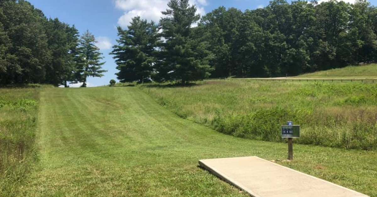 A tee pad leads to a well-groomed, up-sloping fairway