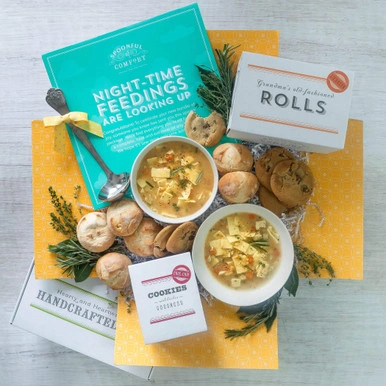 Two bowls of soup sit amidst cookies, rolls, greenery, and a sign that says "Night-time Feedings are Looking Up"