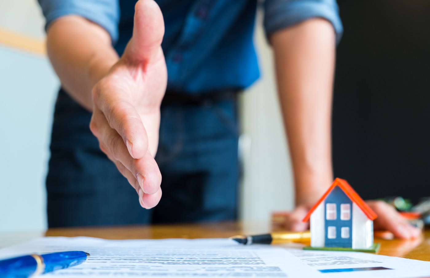 real estate agent with his hand out to give a handshake