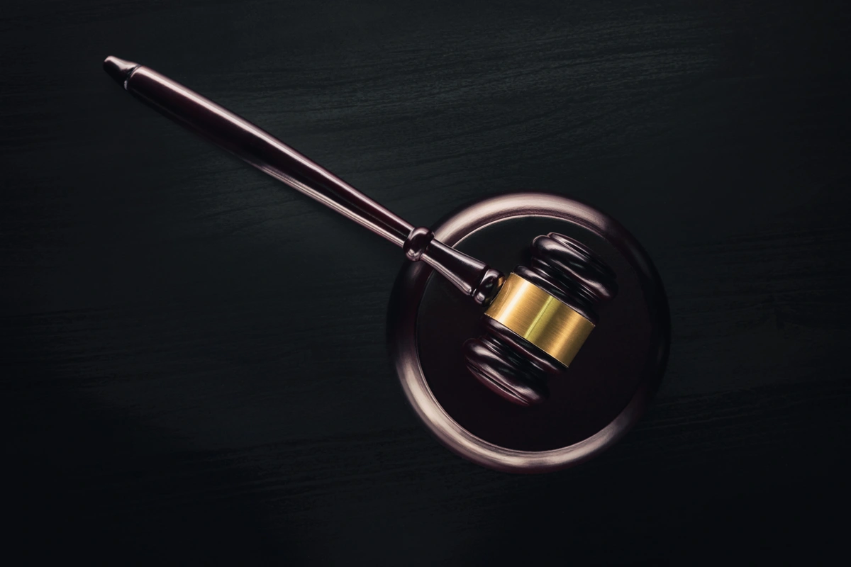 A judge's gavel resting on a dark table, symbolizing justice and legal authority, ideal for use in websites and magazines focused on law and legal matters.